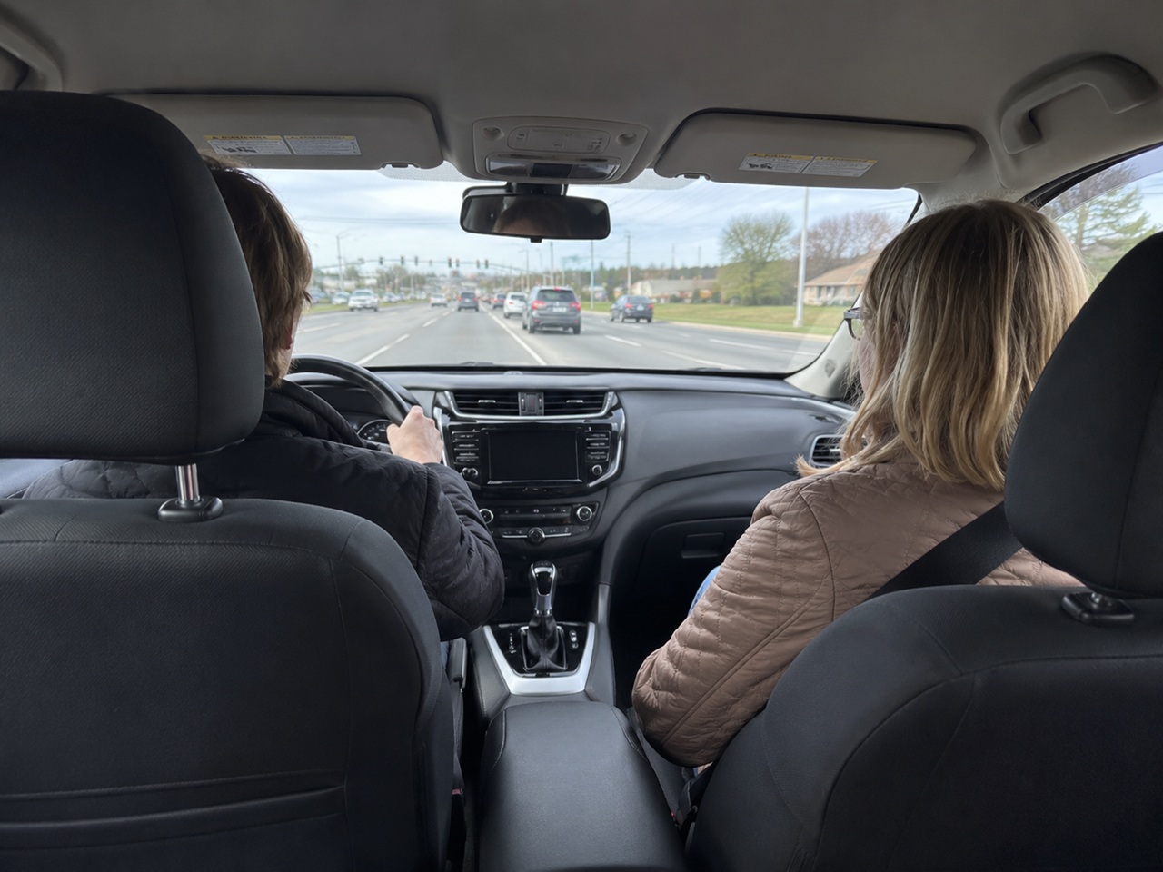 A driver and front seat passenger riding in traffic on a Delaware road, illustrating the legal rights of a passenger injured in a car accident.
